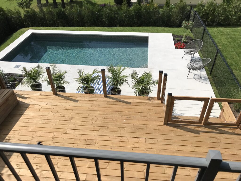Patio en bois sur le bord d'une piscine creusée
